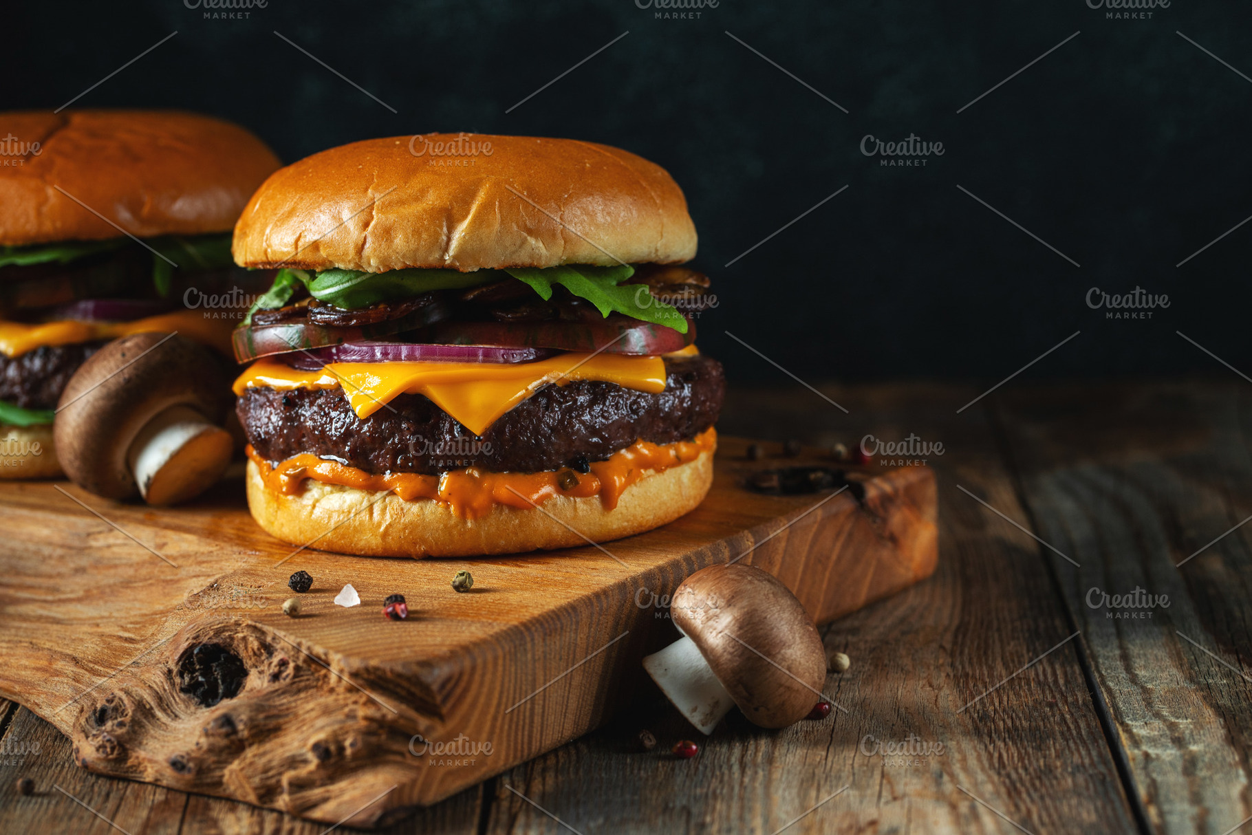 Two delicious homemade burgers of beef, cheese and mushrooms on an wooden table, a Food & Drink Photo by Budarinphoto