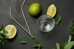 Bunch of fresh green mint, lime slices, glasses and metal straws, a Food & Drink Photo by ndanko