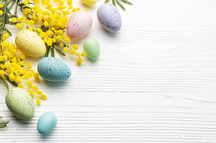 Colorful easter eggs  and mimosa flowers on wooden table., a Holiday Photo by Olena Rudo