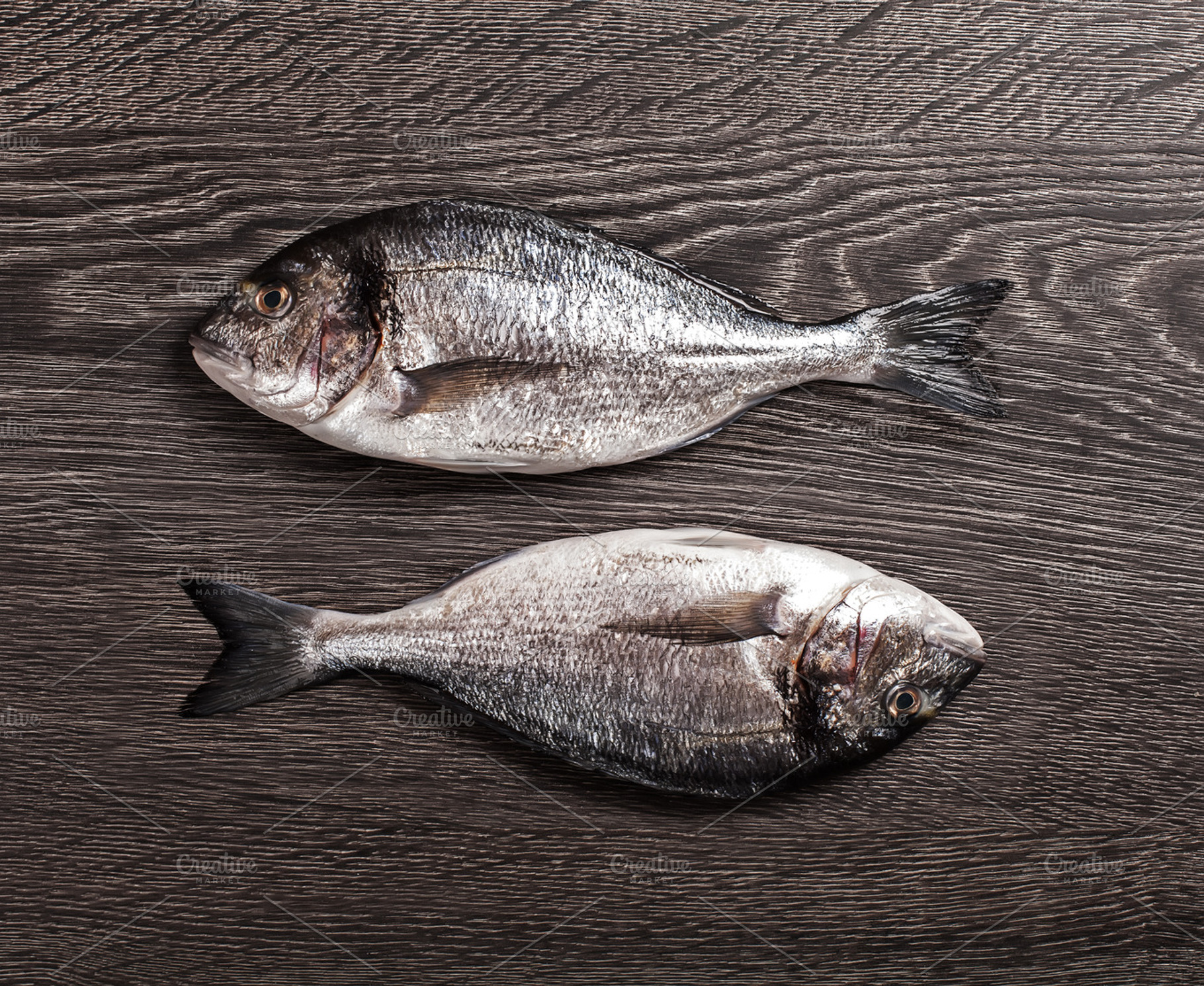 Fresh dorado fish on dark wooden background containing background, board, and