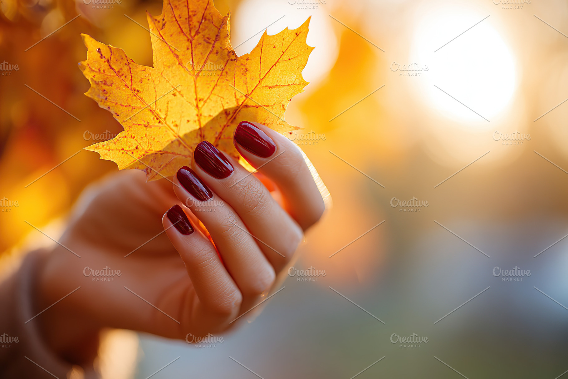 Close-up of a female hand holding a golden leaf with autumn sunlight in the bac, a Photo by AlyaAnd