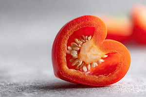 Creative bell pepper slice shaped like a heart on a textured surface, a Food & Drink Photo by AlyaAnd