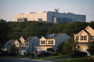 Suburban neighborhood in foreground with large data center visib, a Photo by Dvoevnore photos