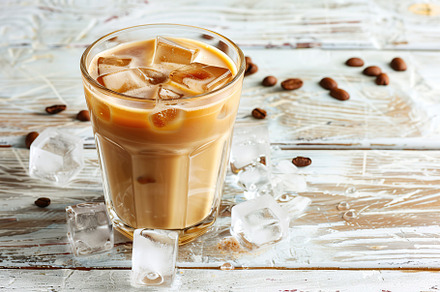 Glass of iced coffee on wooden background, a Food & Drink Photo by AlyaAnd