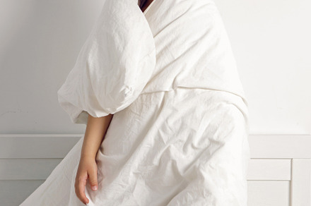 child boy is mad having fun in a white bed in the children's room with a blanke, a Person Photo by SaulichPhoto
