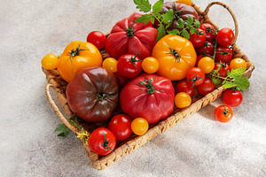 Heirloom tomatoes in a basket showing harvest variety, a Food & Drink Photo by Olena Rudo