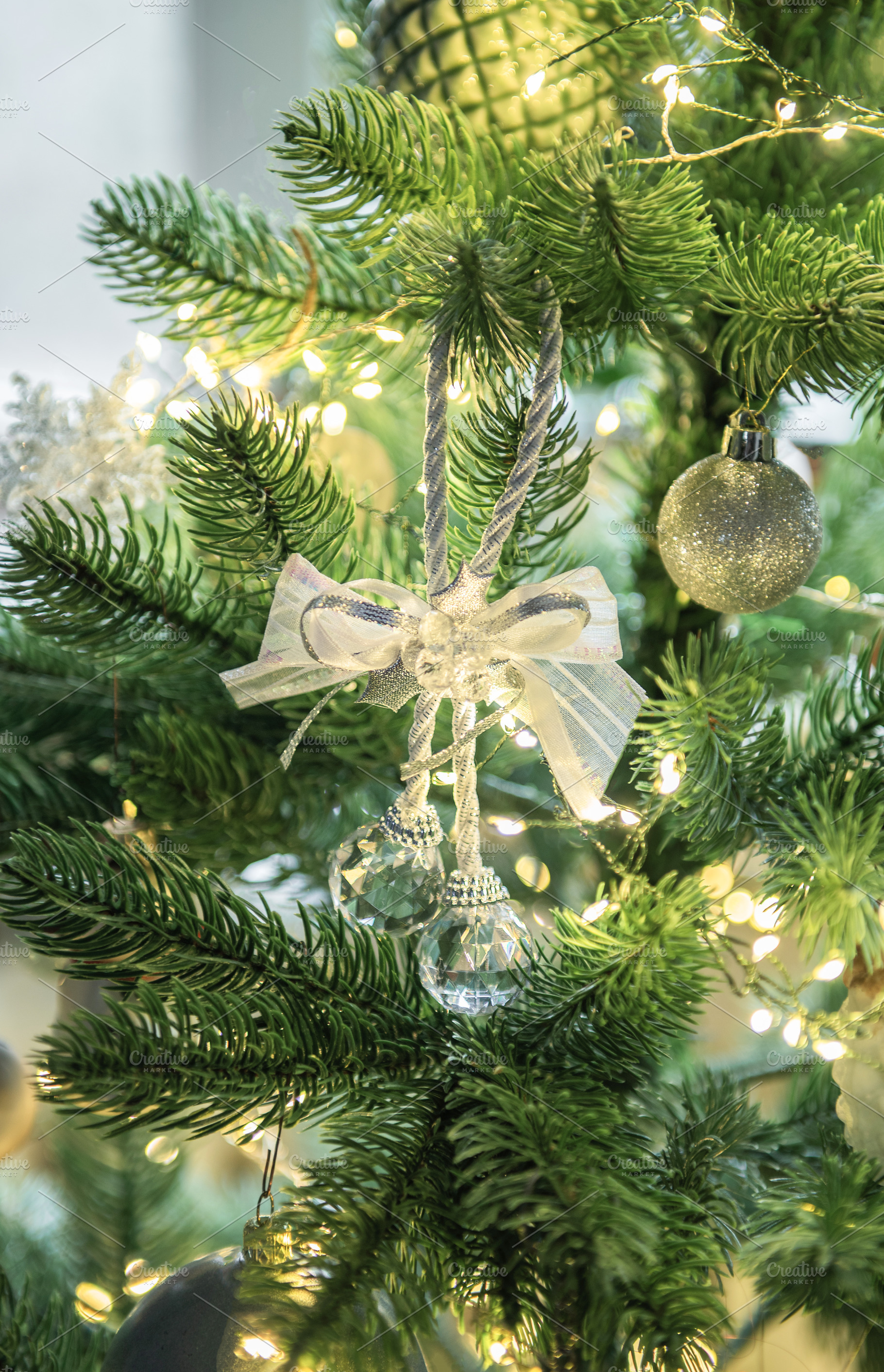 Christmas tree decorating with shimmering silver ornaments and l, a Holiday Photo by Olena Rudo