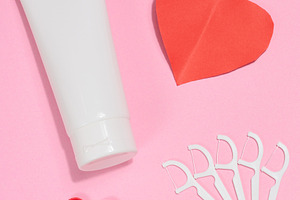 White tube of toothpaste, red paper heart, red decorative lips a, a Health & Medical Photo by ndanko