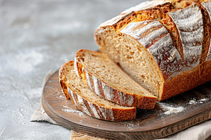 Sliced baked bread on grey background, a Food & Drink Photo by AlyaAnd