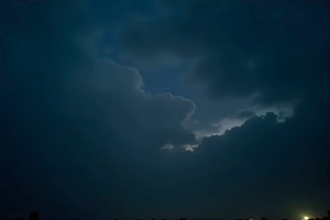 Faint Urban Glow Below Rolling Night, a Photo by LOGOCREATIVE