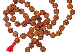 A traditional Rudraksha mala with brown beads and a red tassel,, an Abstract Photo by ndanko