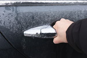 Close-up of a hand opening an icy car door, showcasing winter co, a Transportation Photo by Ales Munt