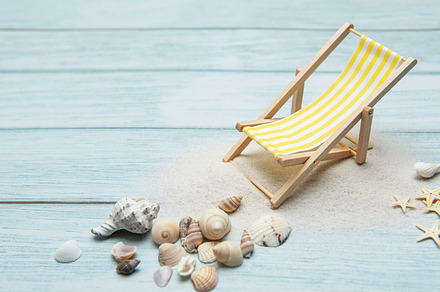 Miniature deck chair on sandy beach with seashells inviting rela