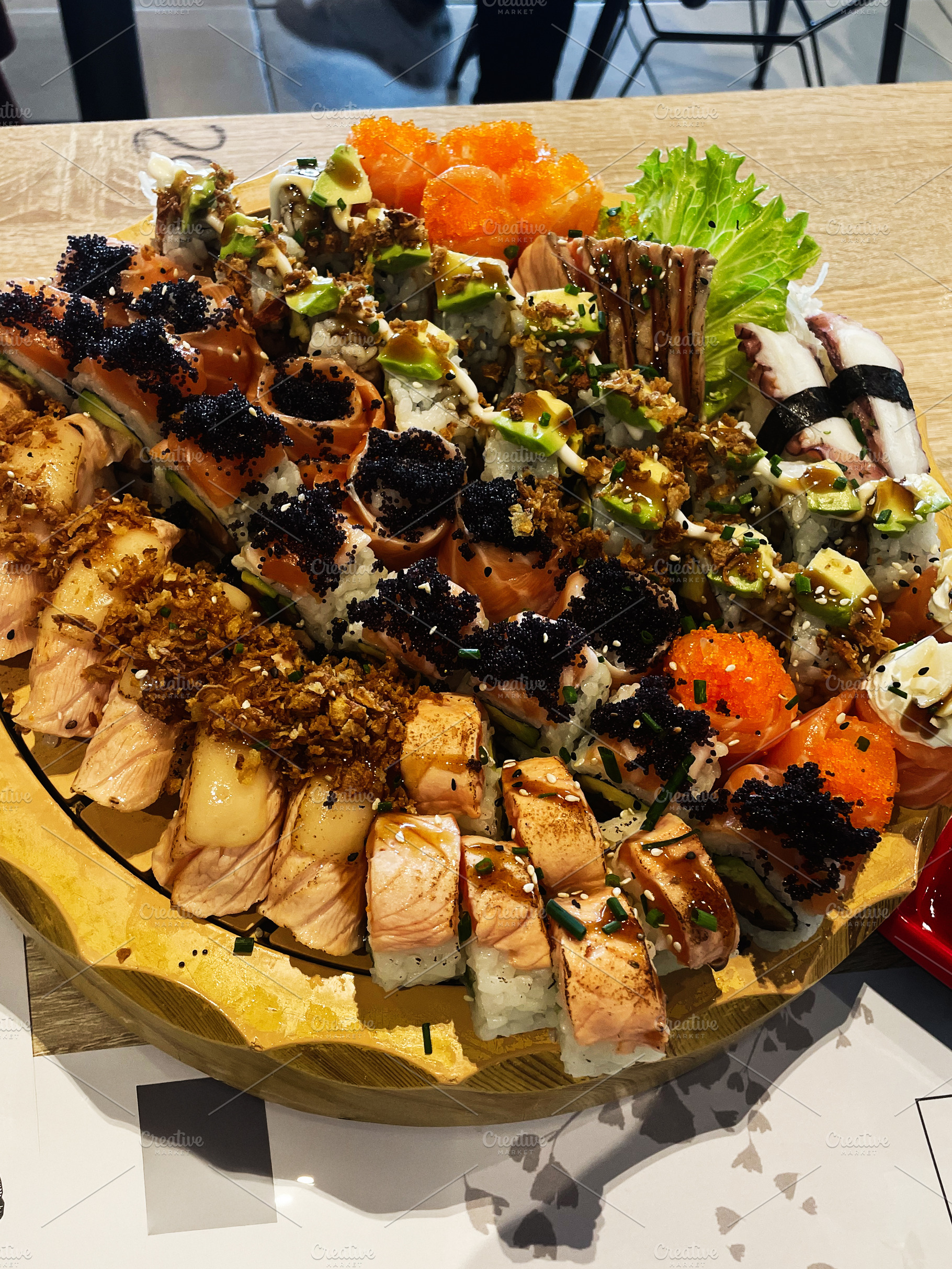 A diverse sushi platter on a wooden board in a restaurant ., a Photo by AS photostudio