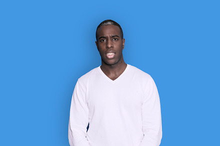 Portrait of cheerful young african-american guy wearing white casual sweater po, a Person Photo by RF Images