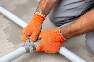 Tightening a pipe fitting in plumbing work, an Industrial Photo by AlyaAnd