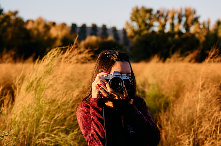 A young woman strolling through the countryside with her vintage camera at suns, a Holiday Photo by YossSabalet