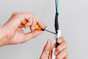 a man connects the electrical cord of a ceiling light