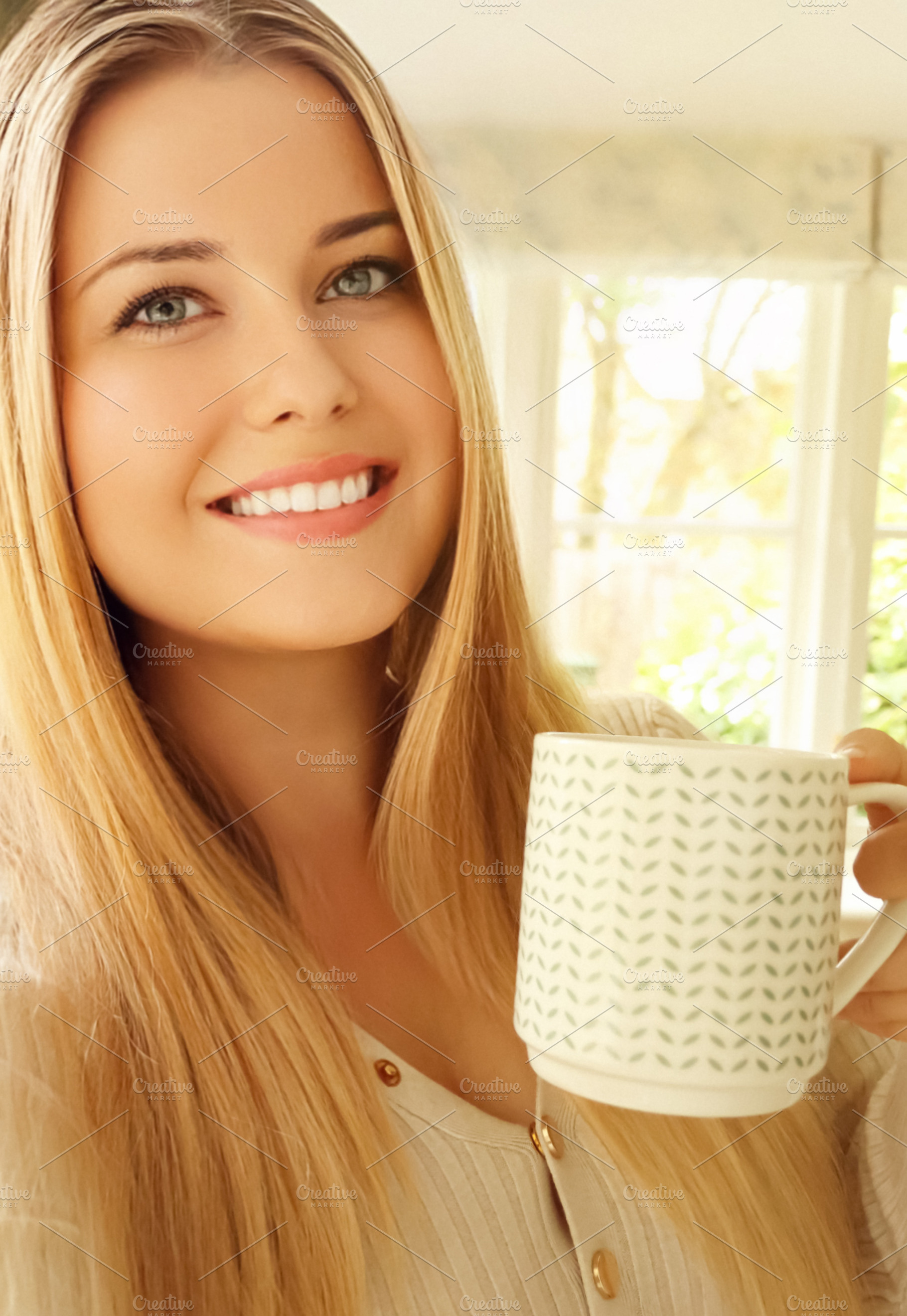 Young blonde woman smiling, holding coffee mug, enjoying morning, a Person Photo by Studio ANNA
