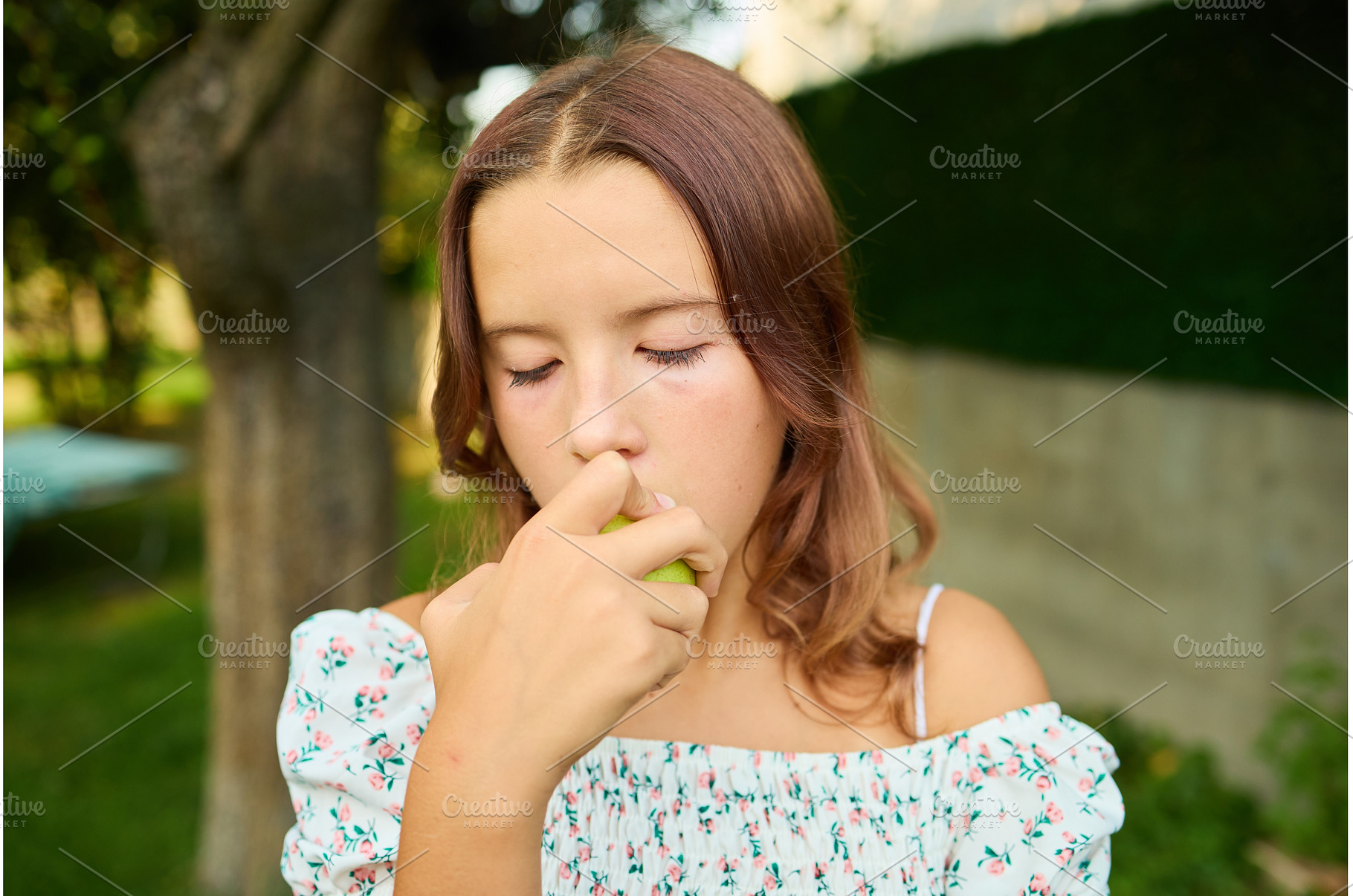 Girl eating a pear while standing in, a Nature Photo by IlliaBondarPhotography