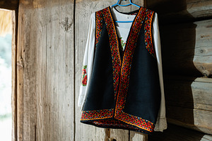 Traditional ukrainian embroidered clothing displayed against rustic wooden back, a Photo by AS photostudio
