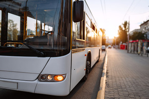 A public bus parked on a city street during sunset, highlighting its sleek desi, a Business Photo by ImageMir