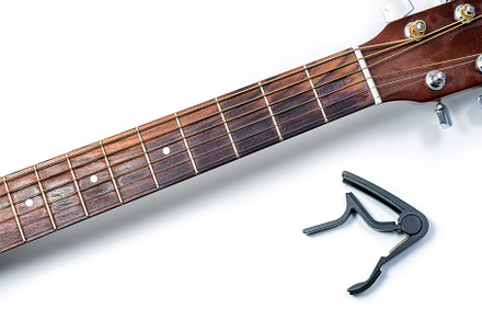 Capo and acoustic guitar, a Photo by wr7 Media
