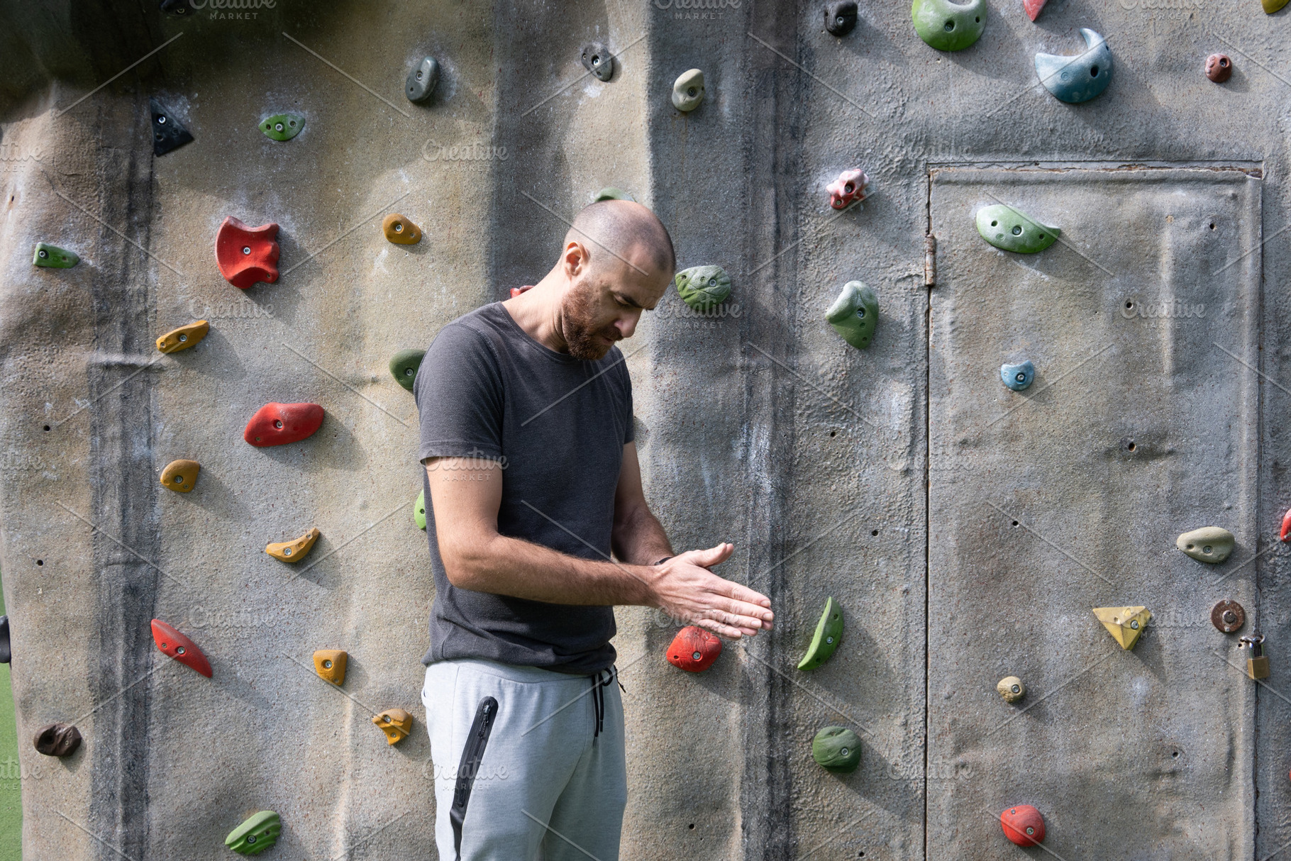 Man Applying Chalk to Hands Before Climbing at Outdoor Bouldering Park, a Person Photo by etorres69
