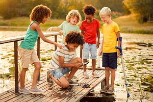 Kids gathering on a wooden pier by the lake, a Person Photo by DanFLCreativo