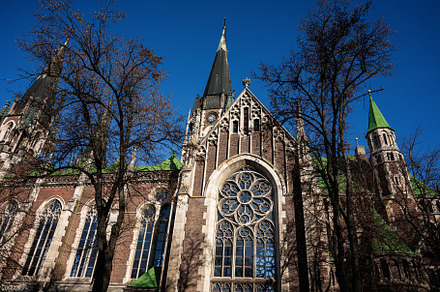 Historic red brick Church of Sts. Olha and Elizabeth exterior with trees and sp, a Photo by AS photostudio