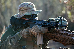 Soldier aiming with assault rifle during airsoft game in forest, a Sports & Recreation Photo by Antonio Gravante Market