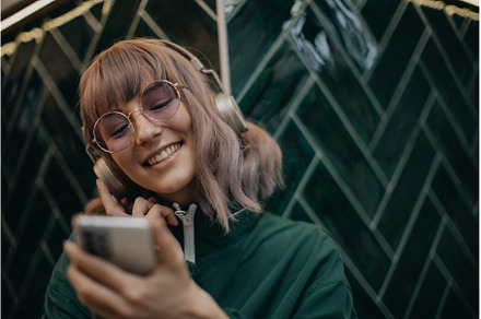 Young woman wearing headphones and, a Person Photo by HalfPoint