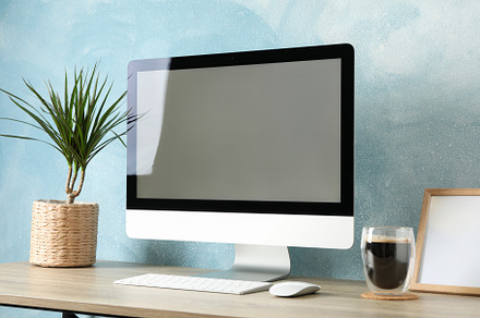Workplace with computer, plant and glass of coffee on wooden tab, a Business Photo by AtlasStudio