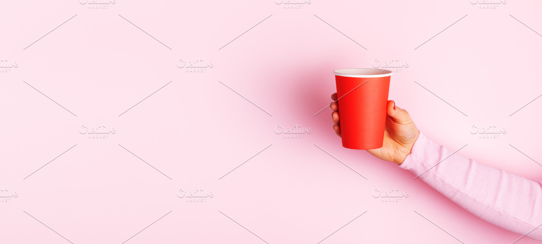 Close-up of hand holding a red paper cup against a pastel pink b, a Food & Drink Photo by Ales Munt