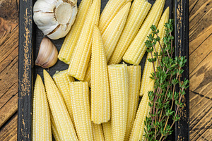 Fresh baby corn cobs in rustic wooden crate with thyme and garli, a Food & Drink Photo by composter-box@mail.ru