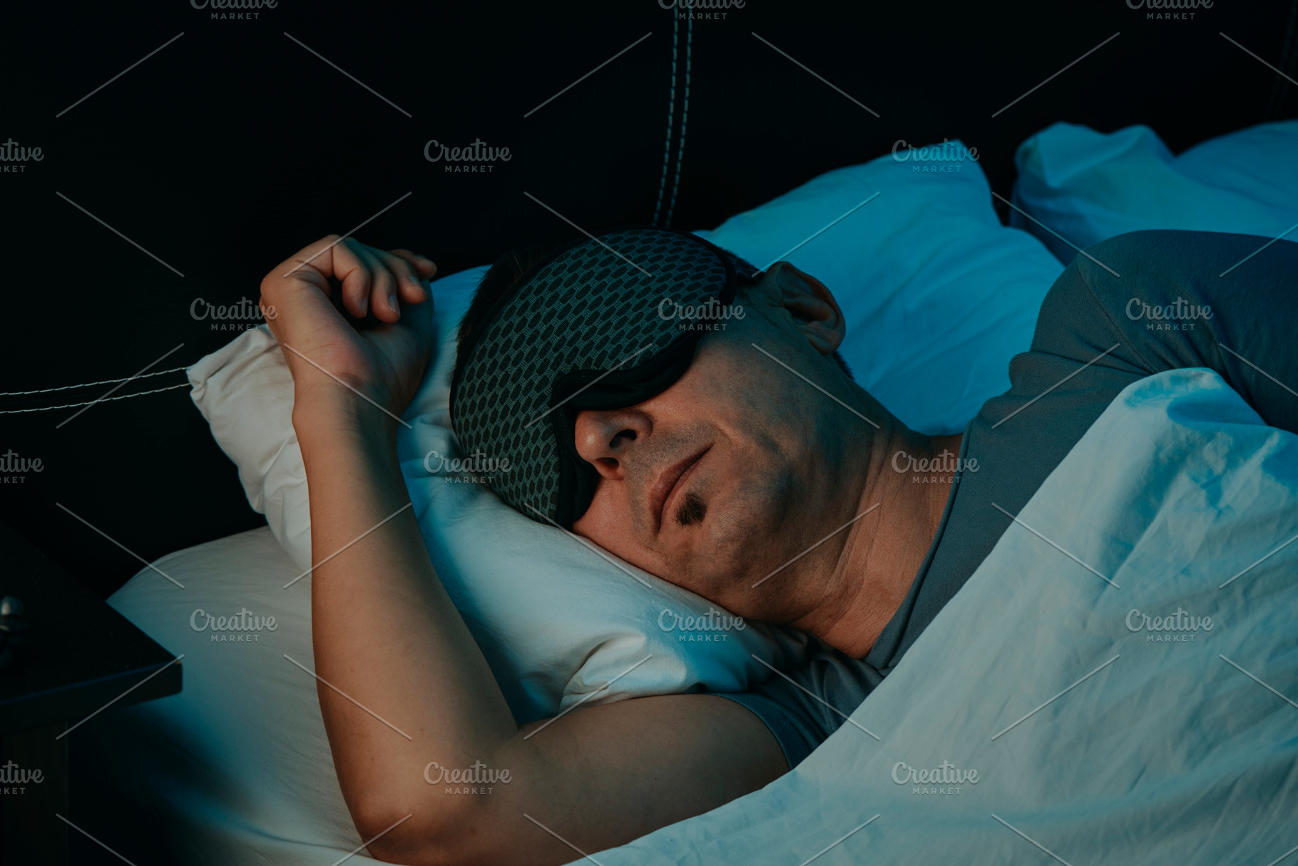 a man resting with a sleep mask in a bedroom, a Photo by Nito