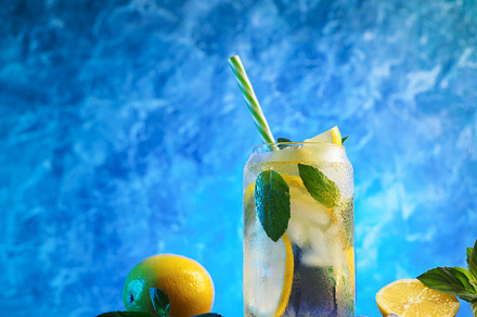 summer cold lemonade with lemon and mint, blue background.