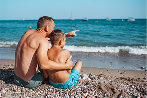 Rear view of son and father looking, a Sports & Recreation Photo by HalfPoint