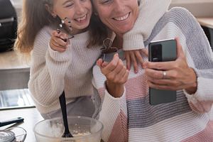 Mother and daughter taking selfie while baking Christmas cookies at home, a Person Photo by etorres69