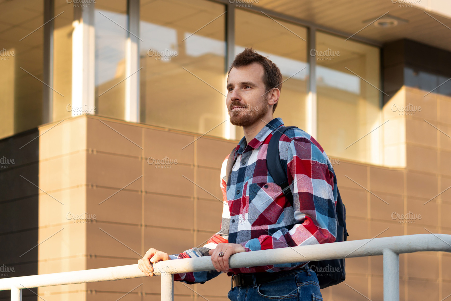 Young adult man standing by railing, a Person Photo by Elena Vagengeim
