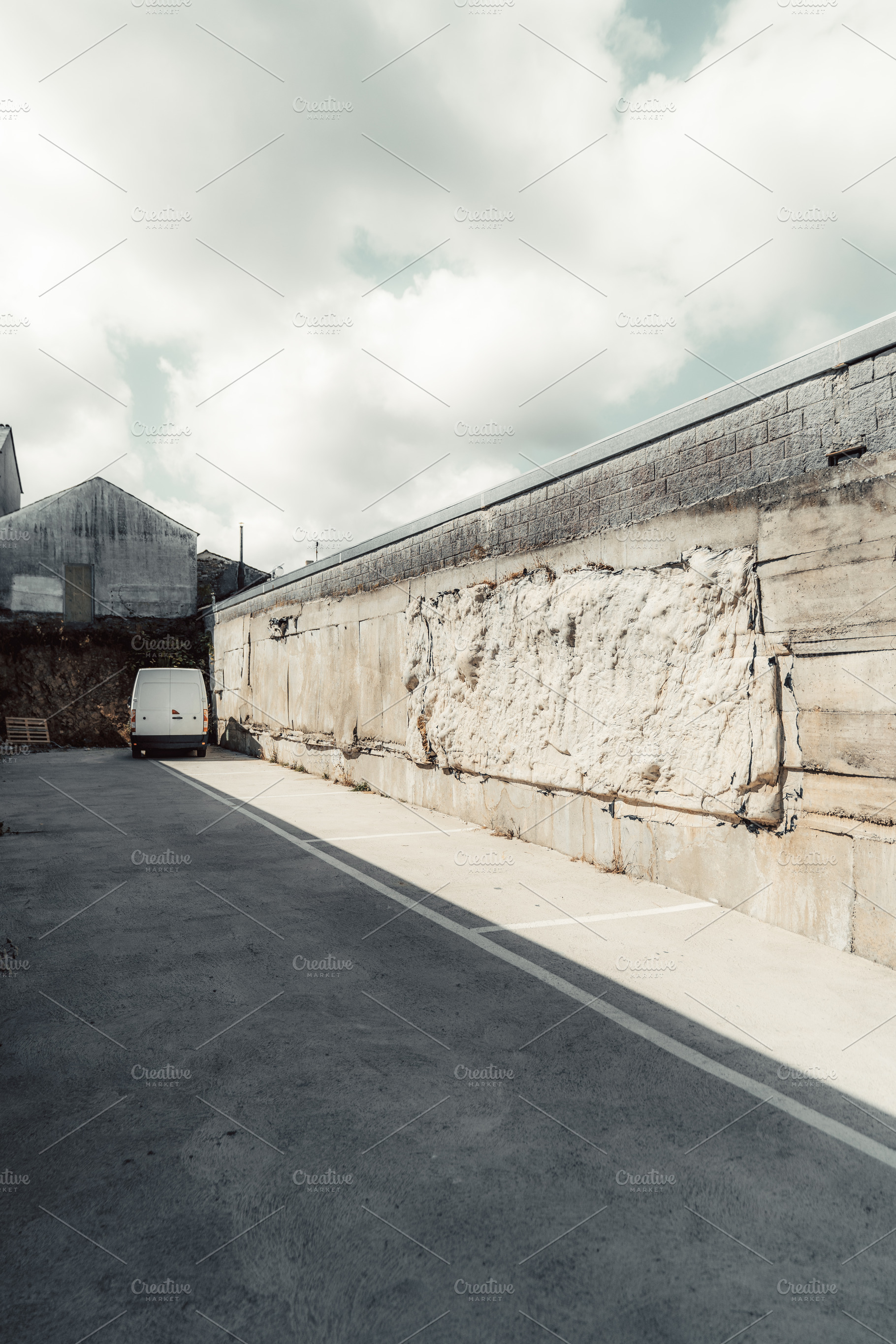 Patched concrete wall and van, a Transportation Photo by SkyNext