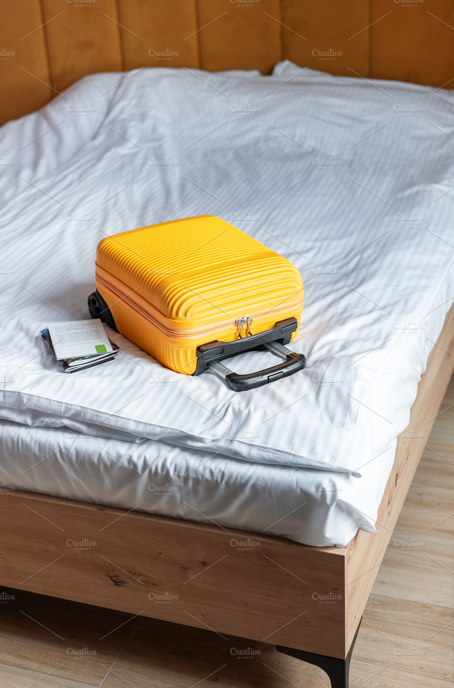 Orange suitcase on hotel bed welcoming travelers arrival, a Holiday Photo by Olena Rudo