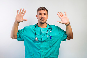 Male Doctor Raising Both Hands Up, a Person Photo by karrastock