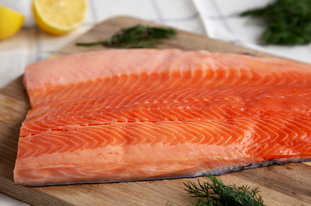 Organic Raw Salmon Fillet on a wooden board, side view., a Food & Drink Photo by LiudmylaChuhunova