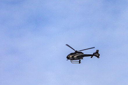 a black helicopter flies against the