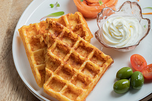 Crunchy waffle fries with sour cream dip served in a basket, a Food & Drink Photo by Budarinphoto