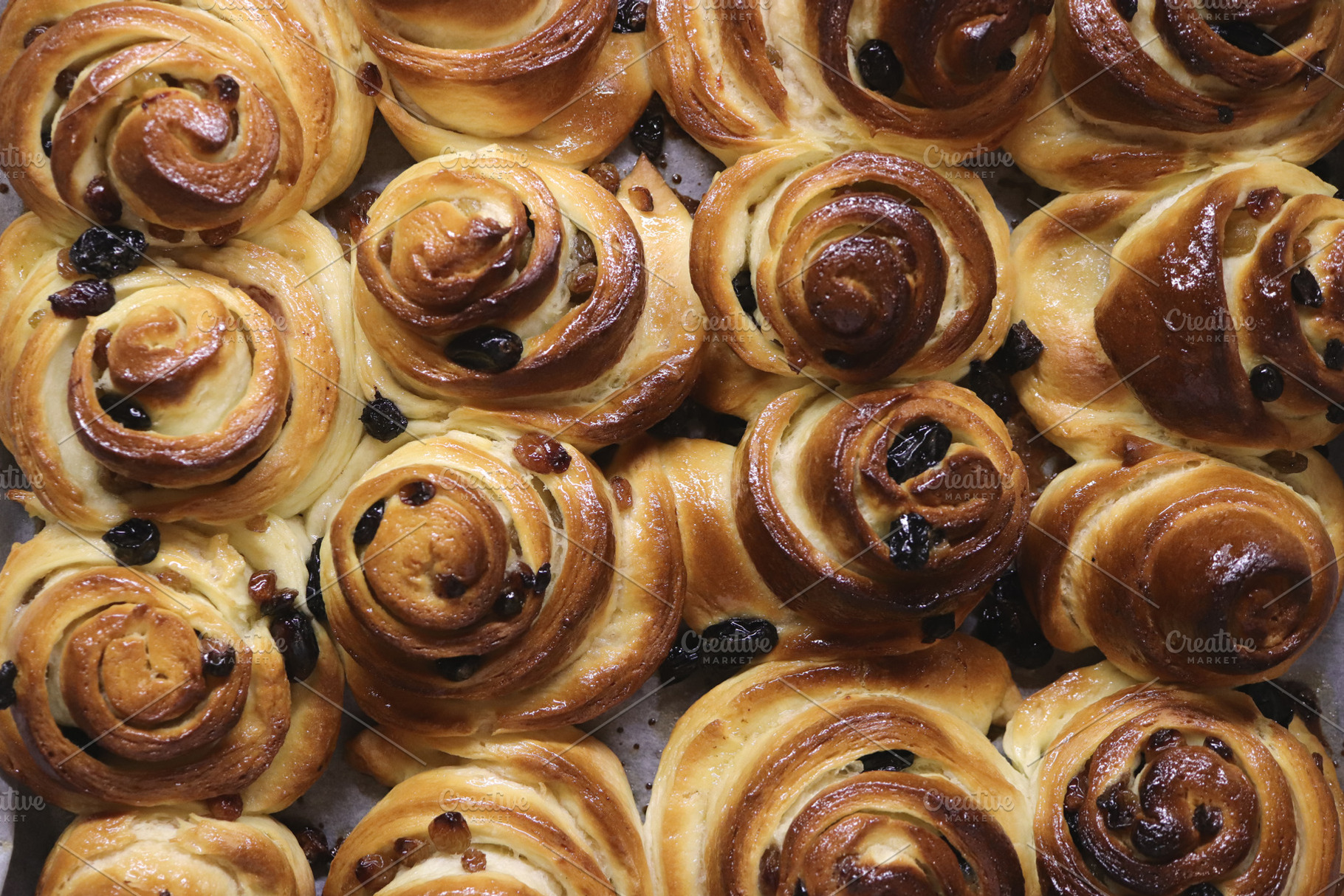 Close-up of freshly baked cinnamon rolls with raisins., a Food & Drink Photo by Textures & Backgrounds
