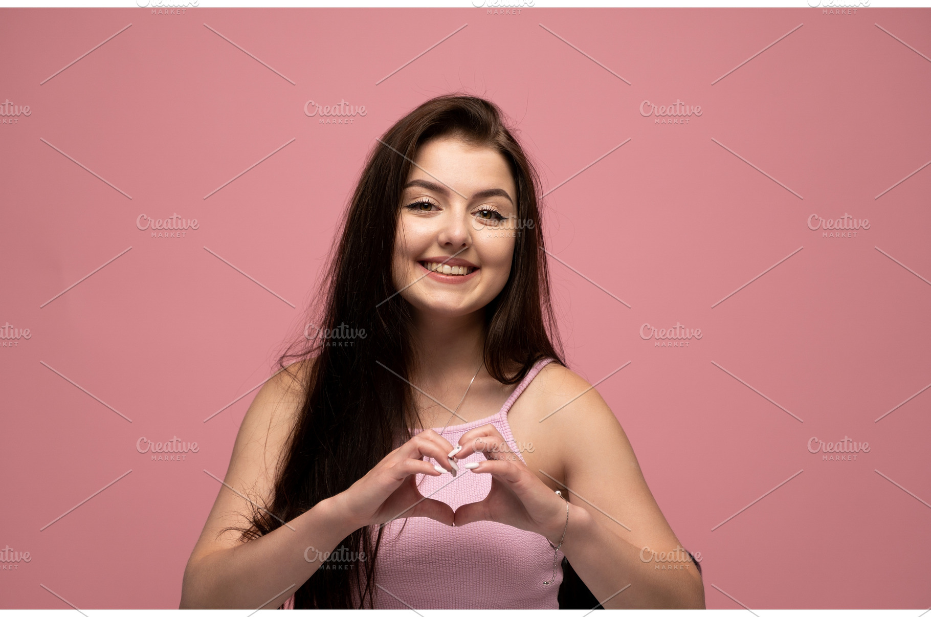 Young smiling woman forming a heart, a Person Photo by volodymyrshtun13795