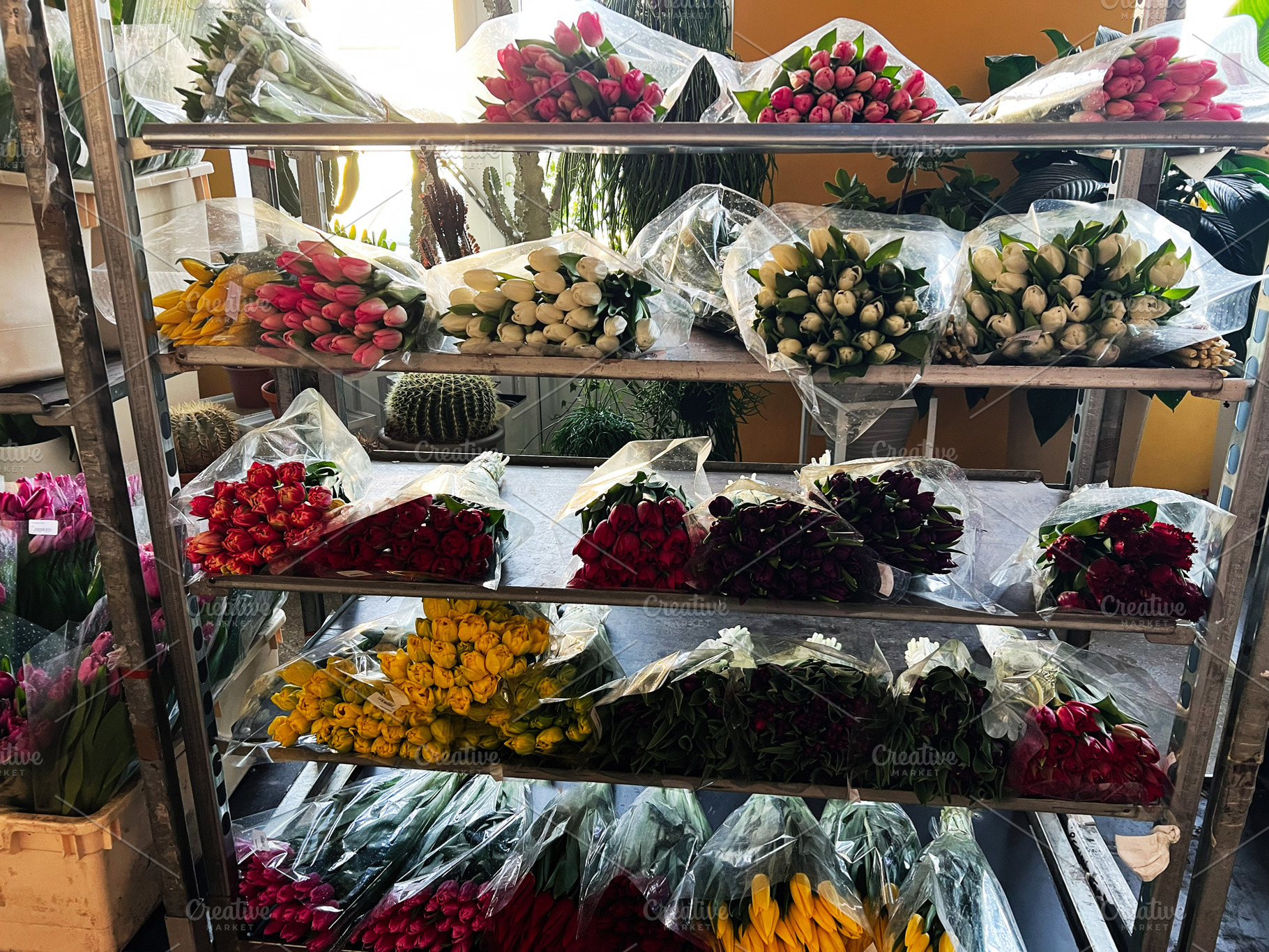 Colorful floral bouquets displayed on metal shelves in a flower shop interior, a Photo by AS photostudio