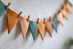 Colorful paper flags hanging decoratively against a textured wall for celebrati, a Background Photo by AlyaAnd